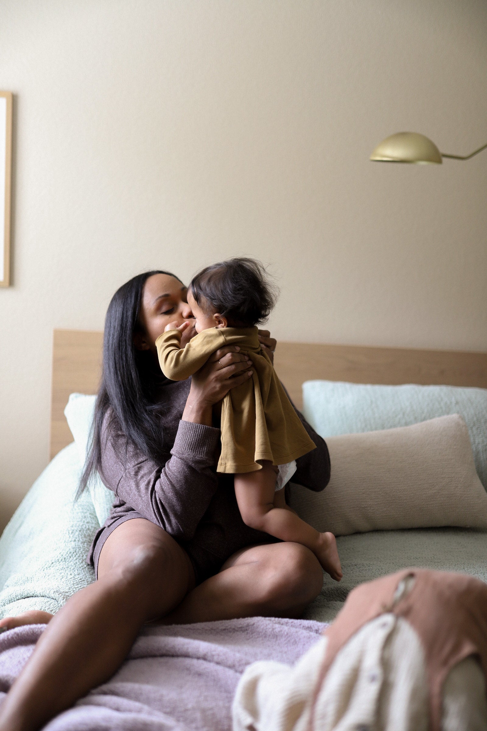 Mom kissing her baby. Woman wearing Sunday Citizen Cosset Relaxed Pullover. 