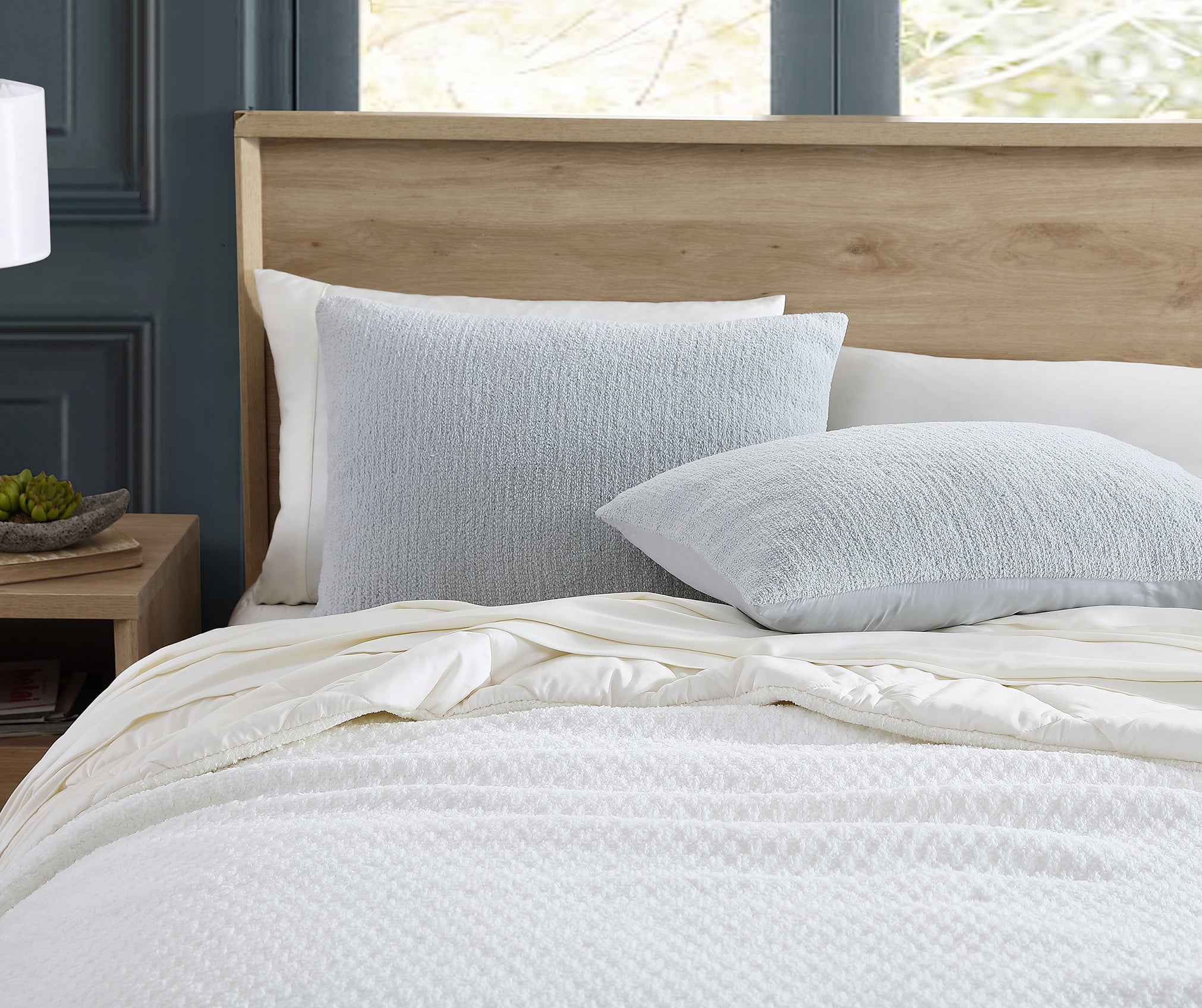What is a Sham? Sunday Citizen's Snug + Bamboo Sham Set in Cloud Grey. Snug Basketweave Comforter in Clear White. Premium Bamboo Sheet Set in Buttermilk. Four pillows on a simple white bed.