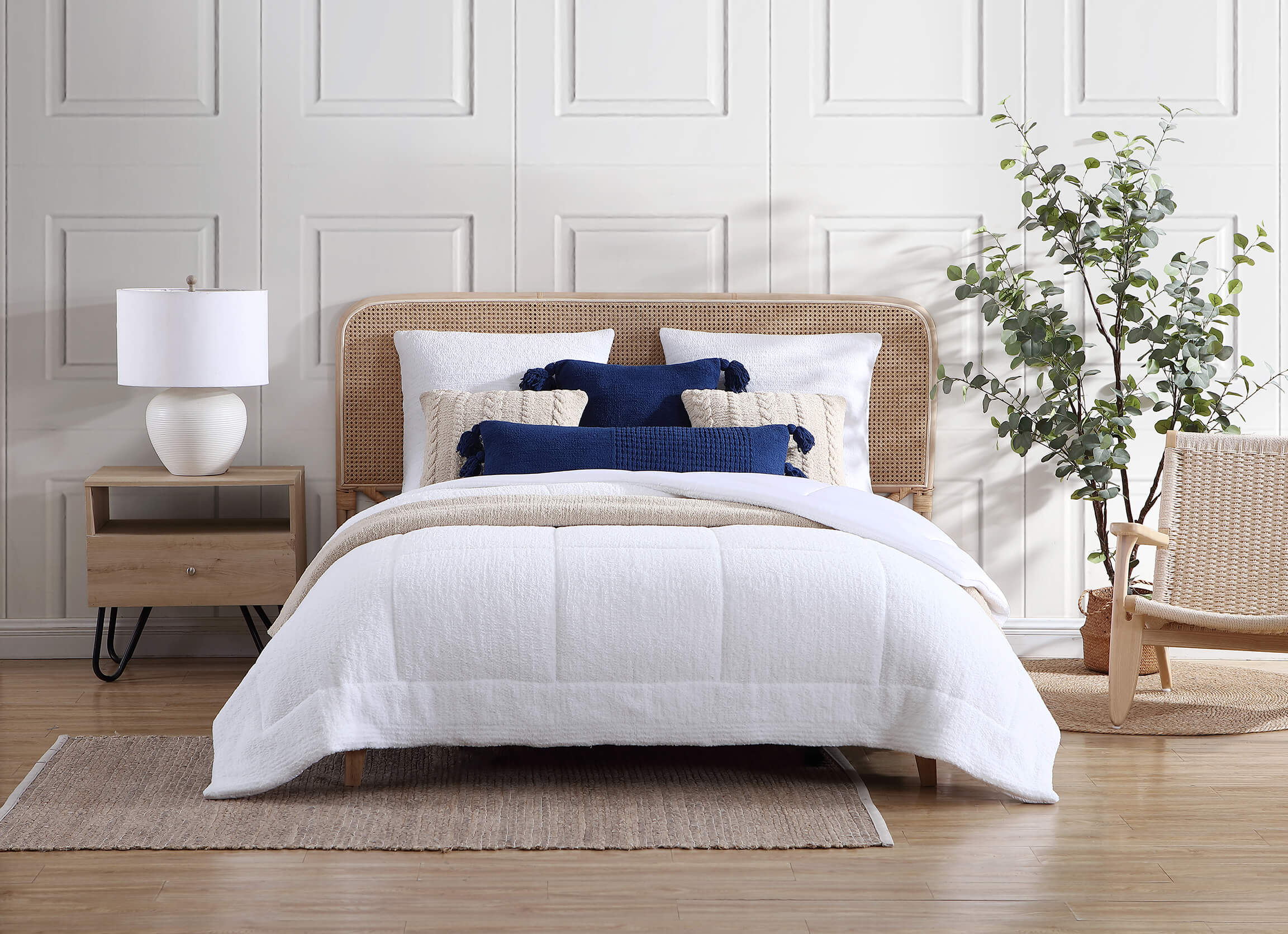 Comforter vs. Duvet. Sunday Citizen Snug Quilted Comforter in Clear White. Blue and Tan throw pillows on a white bedspread.