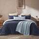 Sunday Citizen Snug Lumbar Pillow in Misty Blue on a bed 