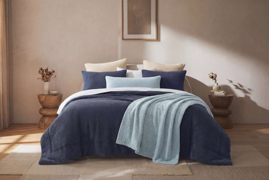 Sunday Citizen Snug Lumbar Pillow in Misty Blue on a bed 