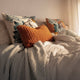 Sunday Citizen Demasc Monkey Throw Pillow in Slate Grey and Koi styled on a modern bed